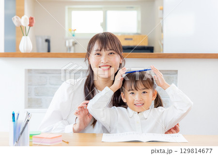 母親と勉強をしている娘 母親と勉強をしている娘 129814677
