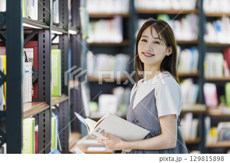 図書館で本を探す若い女性 129815898