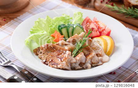 洋食の定番ポークソテーと彩り野菜の盛り合わせ　家庭料理やレストランメニューに最適な一皿 129816048