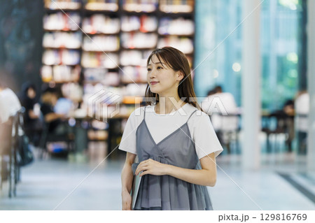 図書館に立つ若い女性 129816769