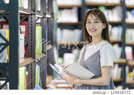 図書館で本を探す若い女性 図書館で本を探す若い女性 129816772