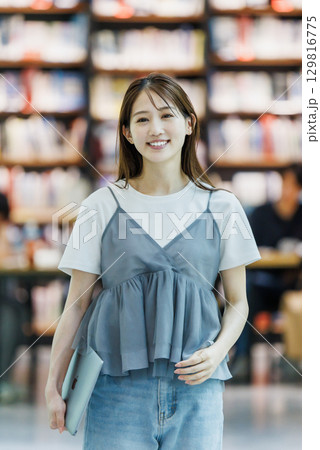 図書館に立つ若い女性 129816775