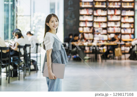 図書館に立つ若い女性 図書館に立つ若い女性 129817108
