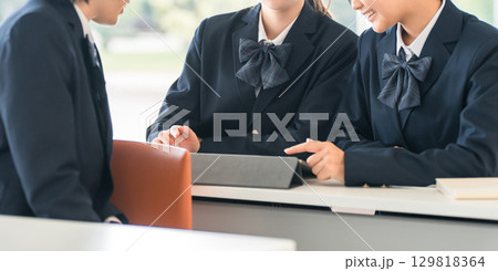 学校で授業中に前の席の生徒と話す小学生・中学生・高校生・女子高生(友達) 学校で授業中に前の席の生徒と話す小学生・中学生・高校生・女子高生(友達) 129818364