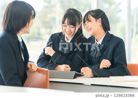学校で授業中に前の席の生徒と話す小学生・中学生・高校生・女子高生（友達） 129818366