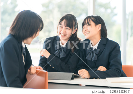 学校で授業中に前の席の生徒と話す小学生・中学生・高校生・女子高生（友達） 129818367