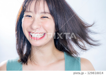 髪をなびかせる女性 129818814
