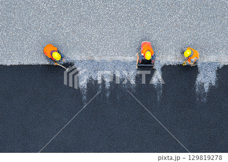 屋根に塗料を塗布する建設作業員を上から見たクローズアップショット 129819278