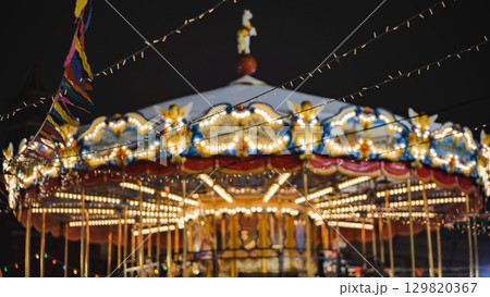 Colorful carousel with lights shining at night in amusement park Colorful carousel with lights shining at night in amusement park 129820367