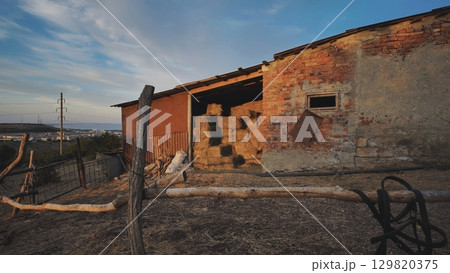 Horse stable with hay bales at sunset in Crimea near Belogorsk 129820375
