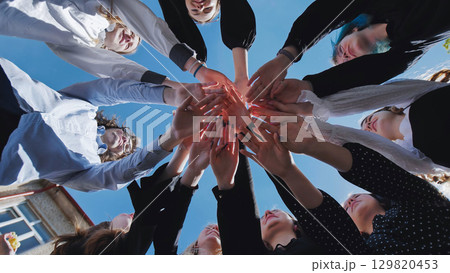 Students forming a circle and celebrating their school day achievement under a clear blue sky Students forming a circle and celebrating their school day achievement under a clear blue sky 129820453
