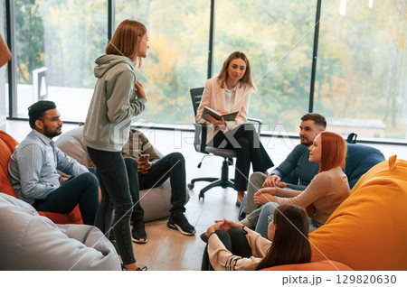Psychologist is sitting and listening. Group of people are having therapy meeting together Psychologist is sitting and listening. Group of people are having therapy meeting together 129820630