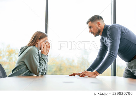 Side view, near big window. Man is screaming at his girlfriend, conception of quarrel 129820796