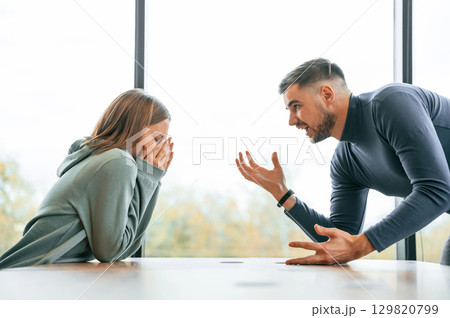 Side view, near big window. Man is screaming at his girlfriend, conception of quarrel 129820799