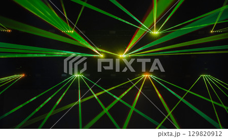 Green laser beams illuminating dark concert hall during music show 129820912