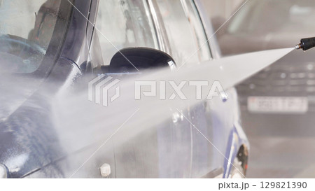High pressure water jet cleaning a car in a car wash High pressure water jet cleaning a car in a car wash 129821390