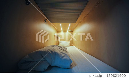 Empty capsule hotel room inviting guests for comfortable overnight stay Empty capsule hotel room inviting guests for comfortable overnight stay 129821400