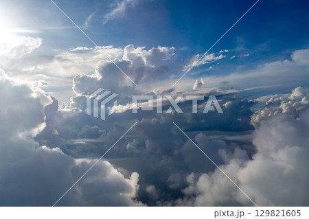 Dramatic sky with sunbeams and clouds seen from an airplane Dramatic sky with sunbeams and clouds seen from an airplane 129821605