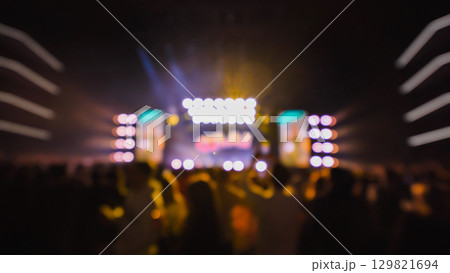 Crowd enjoying live music concert with bright colorful stage lights, blurred defocused bokeh background 129821694