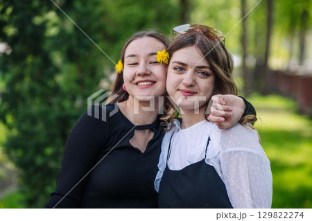 Two happy students embracing and having fun together on a sunny day at school 129822274