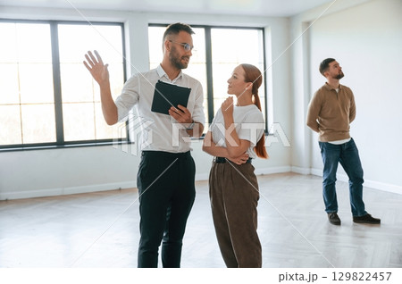 Realtor shows an apartment to a young couple 129822457