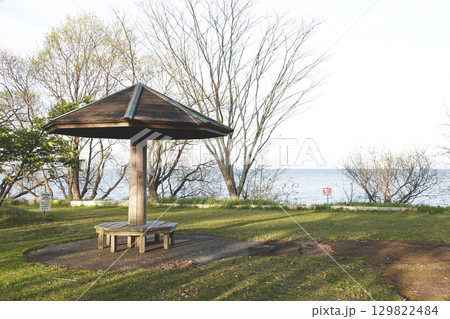 湖畔に建つベンチのある東屋と木立の長い影 湖畔に建つベンチのある東屋と木立の長い影 129822484