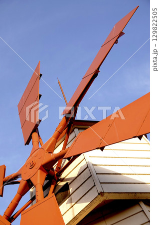 青空の下湖畔に建つ風車 129822505