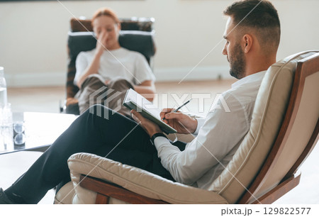 Woman is sitting in chair at an appointment with a psychologist 129822577