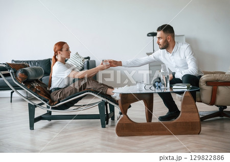 Side view. Woman is sitting in chair at an appointment with a psychologist 129822886