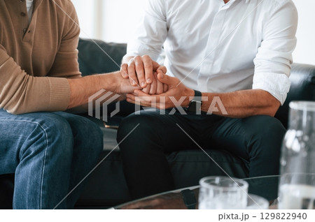Close up view of gay couple that holding hands of each other, supporting Close up view of gay couple that holding hands of each other, supporting 129822940