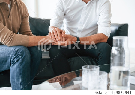 Close up view of gay couple that holding hands of each other, supporting Close up view of gay couple that holding hands of each other, supporting 129822941