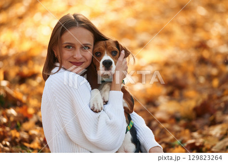 Close up portrait, embracing animal. Woman is with her cute dog in the autumn forest Close up portrait, embracing animal. Woman is with her cute dog in the autumn forest 129823264