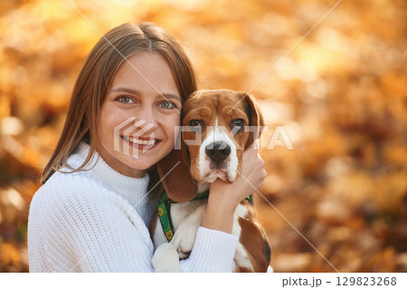 Close up portrait, embracing animal. Woman is with her cute dog in the autumn forest Close up portrait, embracing animal. Woman is with her cute dog in the autumn forest 129823268