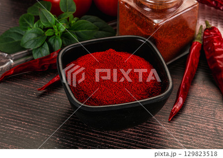 Spicy dry paprika powder in the bowl 129823518