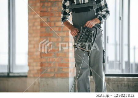 Close up view of repairman indoors in unfinished building Close up view of repairman indoors in unfinished building 129823812