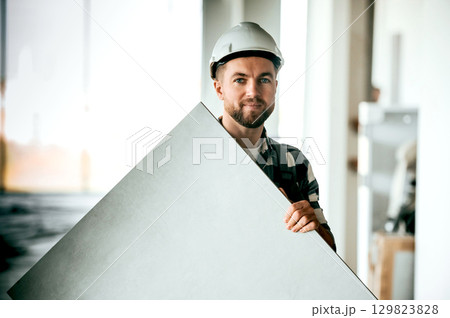 Repairman in uniform is in the unfinished building Repairman in uniform is in the unfinished building 129823828