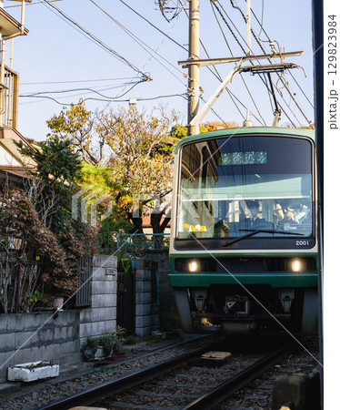 神奈川県鎌倉市腰越、民家の玄関前を走る江ノ電2000型2001号車 129823984