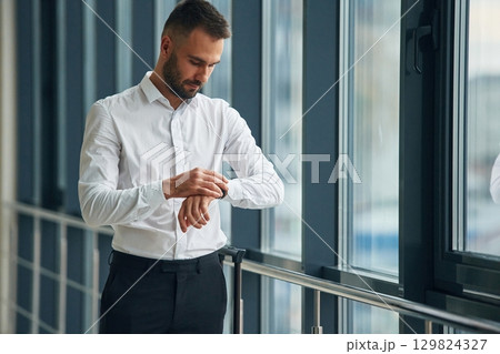 In white shirt and black pants, formal clothes. Young handsome man in the airport In white shirt and black pants, formal clothes. Young handsome man in the airport 129824327