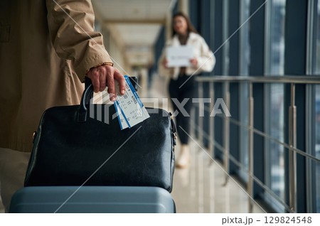 Man arrives from the flight in the airport entrance hall, woman is meeting him with name blank 129824548