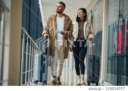 Front view, walking. Couple are in the airport hall together 129824557