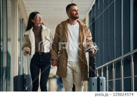 In the airport hall, walking. Couple are together In the airport hall, walking. Couple are together 129824574