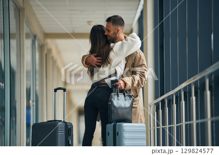 Embracing each other. Couple are in the airport hall together Embracing each other. Couple are in the airport hall together 129824577