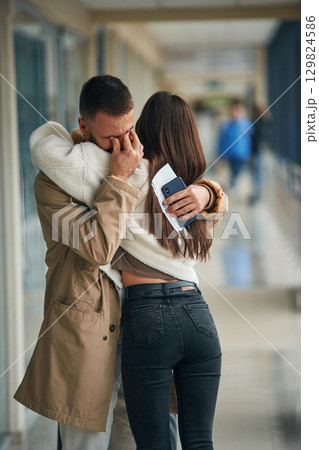 Man is crying, embracing, farewell. Couple are in the airport hall together Man is crying, embracing, farewell. Couple are in the airport hall together 129824586
