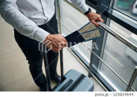 Close up view of man with luggage and in formal clothes, conception of airport travel Close up view of man with luggage and in formal clothes, conception of airport travel 129824644