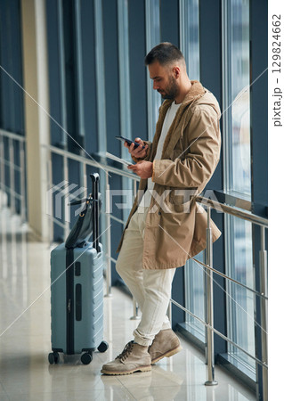 Waiting, standing inside. Young handsome man in the airport Waiting, standing inside. Young handsome man in the airport 129824662