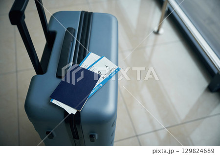 Luggage bag with tickets for flight on it, close up view 129824689