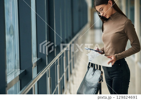 Young woman traveler in the airport entrance hall Young woman traveler in the airport entrance hall 129824691