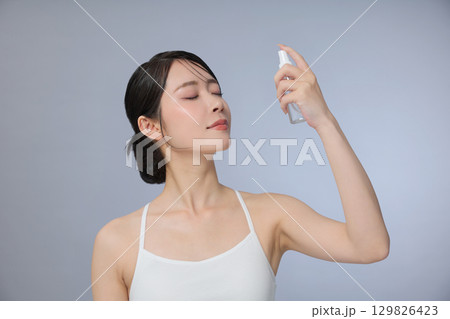 ビューティーイメージ 化粧水を吹きかける若い女性 ビューティーイメージ 化粧水を吹きかける若い女性 129826423