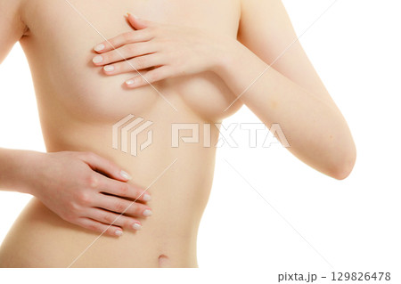 Woman examining her breasts for breast cancer 129826478