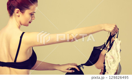 woman choosing bras to wear woman choosing bras to wear 129826495